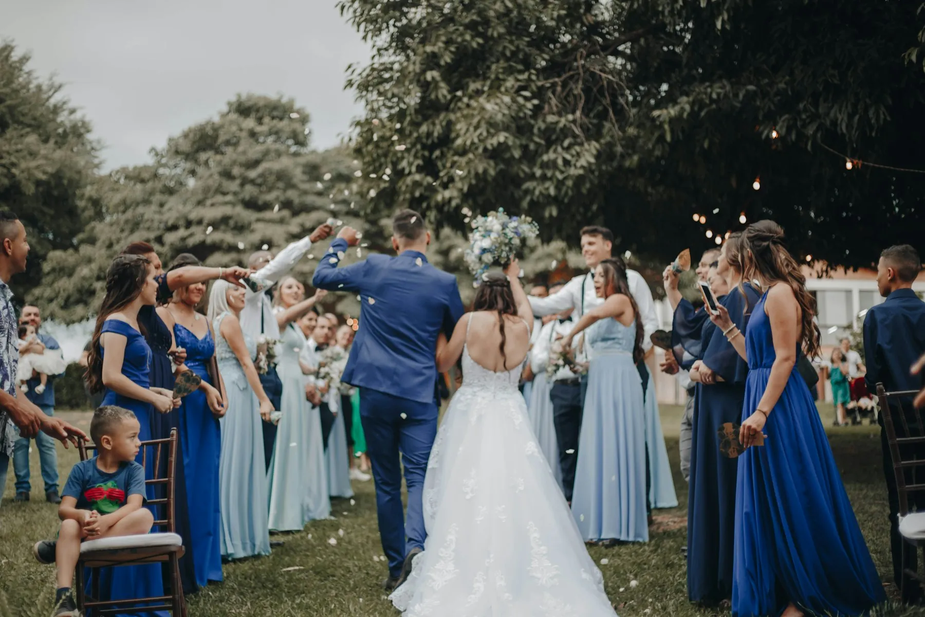 Bride and groom walking back down the aisle together, guests celebrating in Louisville KY